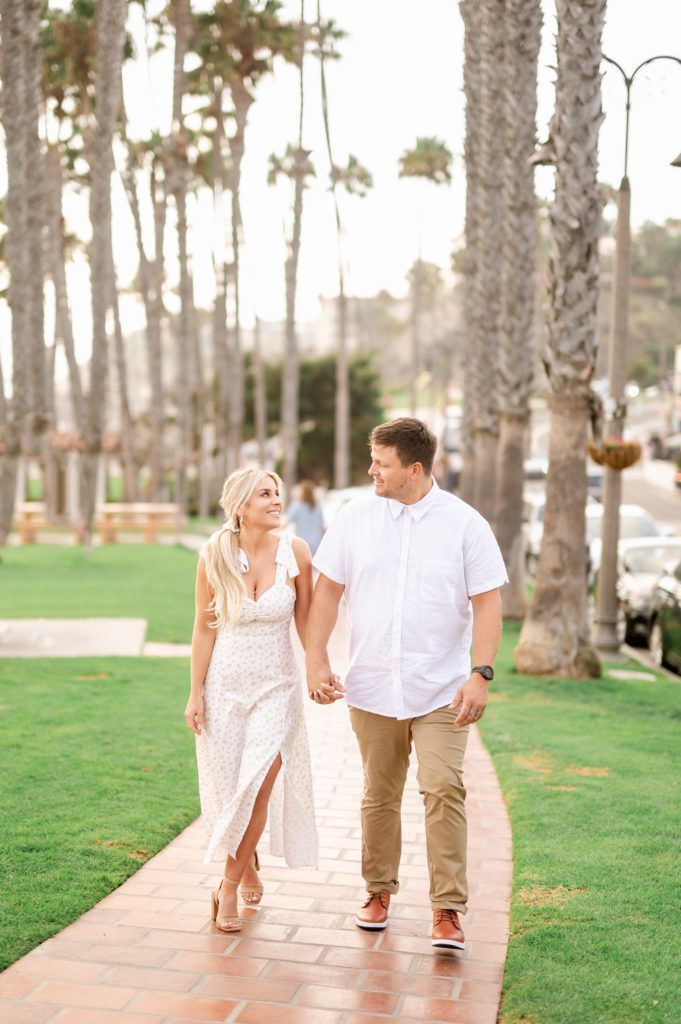Couple walking in white and tan outfits in san clemente, california 